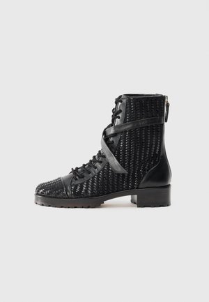 Black lace-up ankle boots with woven texture, smooth accents, rubber sole, and a side zipper. Features a round toe and block heel.