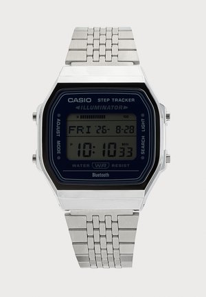Ασημί ψηφιακό ρολόι Casio με μετρητή βημάτων, Bluetooth, αντοχή στο νερό και οθόνη που δείχνει ημερομηνία και ώρα.