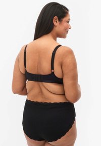 Black bra with adjustable straps and hook closure; paired with high-waisted black lace-trimmed underwear. Smooth, soft texture.
