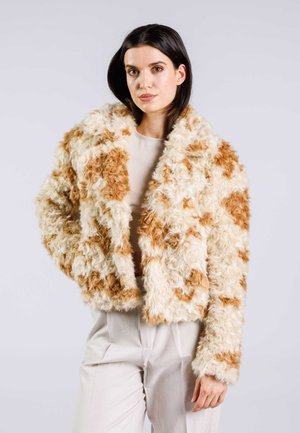 Faux fur cropped jacket in cream with light brown patches. Features a wide collar and textured, curly fabric for added warmth.