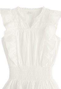 Vit ärmlös topp med volangkrage, smockad midja och textil med subtila detaljer.