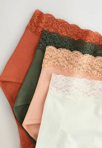 Quatre pièces de sous-vêtements en coton avec des ceintures en dentelle aux couleurs rouille, vert foncé, pêche et blanc, disposées en chevauchement sur une surface pâle.