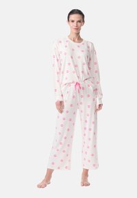 Long-sleeve pajama set in soft white fabric, featuring scattered pink lips print, with elastic waistband and a pink drawstring.
