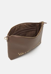 Clutch in pelle marrone con accessori dorati. Presenta una chiusura con zip e una tasca interna a scomparsa. Texture liscia con logo del marchio stampato.