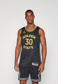 Sort basketballtrøje med "GOLDEN STATE 30" i gult, blå accenter og mesh tekstur, parret med sorte shorts med hvid trim.