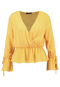 Blusa gialla a maniche lunghe con scollo a V e vita a peplum. Tessuto leggero e morbido con dettagli arricciati ai polsini e in vita.