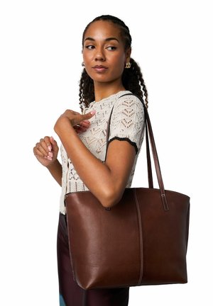 Hnedá kožená taška cez rameno s kontrastným bielym prešitím, vybavená dvoma ramennými remienkami a štruktúrovaným obdĺžnikovým tvarom.