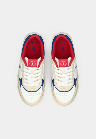 Sneakers med ovandel i beige läder, blå swoosh-design och röd inredning. Har vita snören och perforerad tå för andningsförmåga.