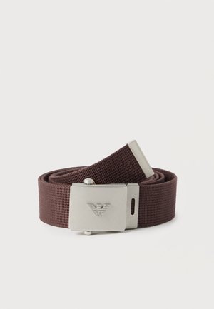 Ceinture en tissu marron tressé enroulée avec une boucle en métal argenté ornée d'un logo en relief.