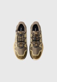 Pair of olive green and tan athletic trail running shoes with black quick-lace system on white background, viewed from above.