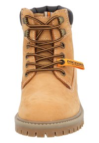 Skórzane buty trekkingowe w kolorze brązowym z brązowymi sznurówkami, metalowymi oczkami i wyściełanym kołnierzem. Posiadają wytrzymałą gumową podeszwę z głębokim bieżnikiem.