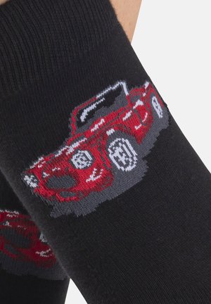 Schwarze Socken mit einem gestrickten Design eines roten Autos, mit grauen Akzenten und weißen Details. Die Textur ist glatt mit einem gerippten Bund.