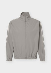 Heledast hall, tõmblukuga spordijakk kõrge krae, elastsete mansettide, ääre ja õhukeste valgete triipudega, mis jooksevad varruka pikkuses.