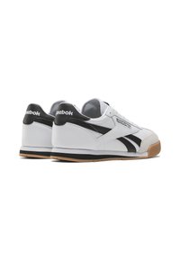 White sneakers with black accents, smooth leather upper, suede toe detail, and rubber gum sole. Featuring the Reebok logo on the heel and side.