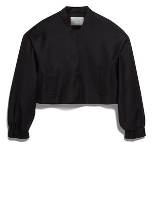 Mustassa lyhyessä takissa on pystykaulus, pitkät hihat, elastiset hihansuut ja kaksi etutaskua. Sujuva pinta, jossa on matta viimeistely.