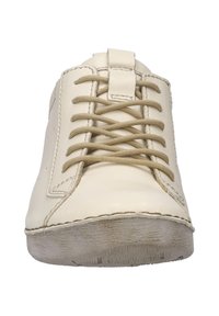 Jasno beżowy skórzany sneaker z zaokrąglonym czubkiem, płaskimi beżowymi sznurowadłami i teksturowaną gumową podeszwą. Minimalne przeszycia i brak widocznych logo.