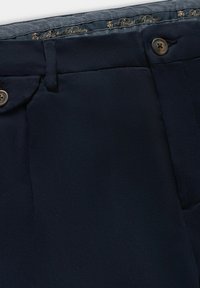 Granatowe spodnie o dopasowanym kroju, wykonane z lekkiego materiału, o gładkiej fakturze, z dwiema przednimi kieszeniami oraz ozdobnym guzikiem z logo.