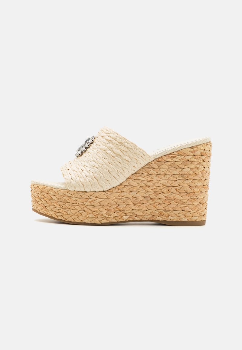 Sandale beige tissée à talon compensé avec bout ouvert, semelle plateforme et ornement décoratif argenté sur la bride.