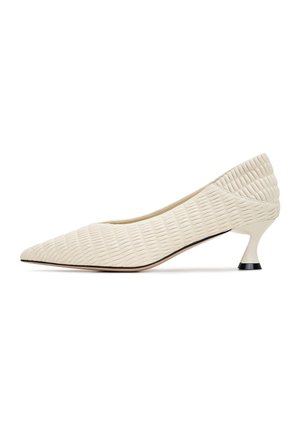 Pantofole con tacco alto bianche e textured, con punta affusolata e un tacco unico a campana, caratterizzate da un motivo a righe sulla parte superiore e un accento nero sul tacco.