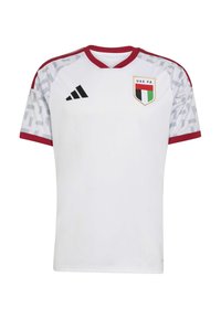Maglia da calcio bianca con accenti rossi, maniche corte, design a V, spalle con motivo e scudetto della FA degli Emirati Arabi Uniti sul lato sinistro del petto. Logo Adidas sulla destra.