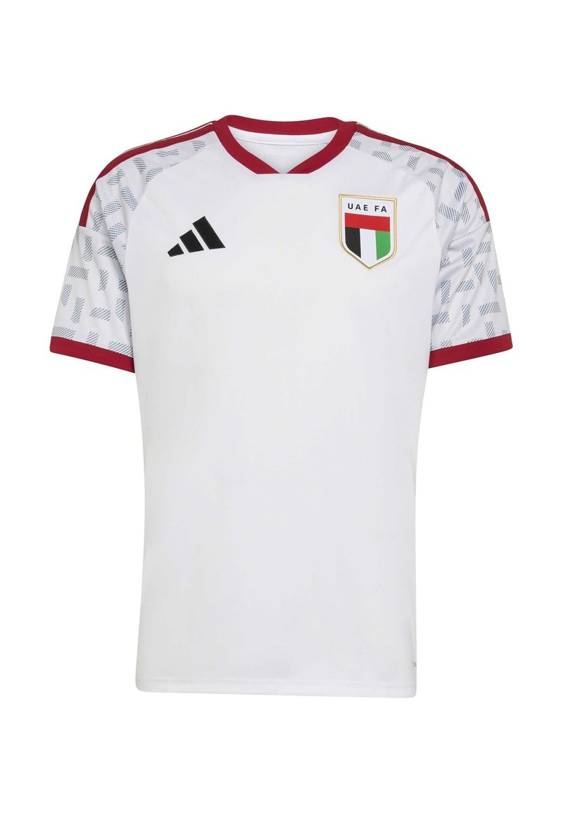 Maglia da calcio bianca con accenti rossi, maniche corte, design a V, spalle con motivo e scudetto della FA degli Emirati Arabi Uniti sul lato sinistro del petto. Logo Adidas sulla destra.