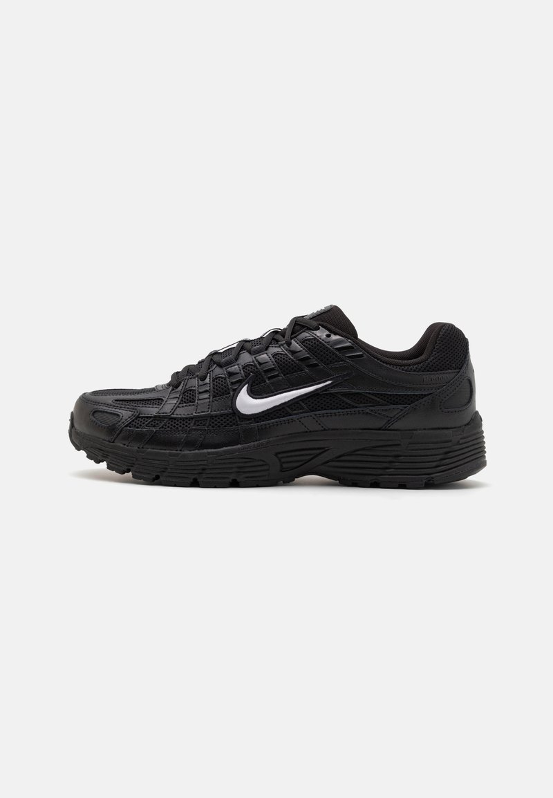 Baskets de sport noires avec une tige en maille texturée et une semelle en caoutchouc. Logo emblématique en swoosh blanc sur le côté, avec un design à lacets.