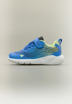 Blauer und gelber Kindersneaker mit weißer strukturierter Sohle, Klettverschluss, Zuglasche an der Ferse und wellenförmigem Muster an den Seiten.