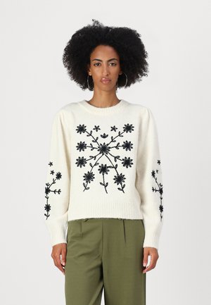 Crème trui met zwarte bloemenborduursels, geribbelde ronde halslijn en lange mouwen. Gekocht bij olijfgroene broeken.