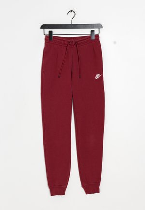 Pantalon de survêtement Nike bordeaux avec taille élastique et cordons, chevilles resserrées, suspendu sur un cintre en plastique noir sur fond blanc.