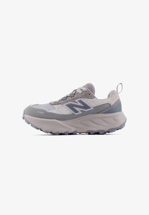 Chaussure de course New Balance grise et violet clair avec une semelle épaisse, un laçage à l'avant, un tissu en maille respirant et "Toe Protect" sur le côté avant.