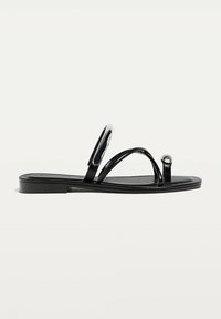 Svarta platta sandaler med glansiga remmar, öppen tå-design, cirkulär detalj och slät sula. Minimalistisk och stilren design.