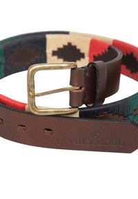 Cinturón tejido colorido con patrones en rojo, verde y beige, con una correa de cuero marrón y una hebilla de latón. El logotipo está grabado en el cuero.