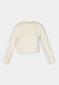 Felpa beige tagliata con maniche lunghe, colletto rotondo e logo Calvin Klein discreto, con polsini a coste e texture uniforme.