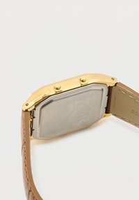 Złoty prostokątny zegarek z stalowym tyłem, brązowym skórzanym paskiem i dwoma bocznymi przyciskami. Teksturowany pasek z widocznymi detalami szycia.
