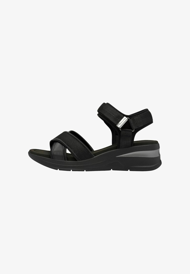 Sandale noire avec larges sangles et soutien de cheville réglable, présentant un dessus en synthétique lisse, une semelle rembourrée et un design de talon compensé élégant.