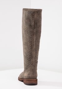 Botte haute en daim marron avec une surface texturée présentant un motif en losanges, un talon en bois empilé et un bout arrondi.