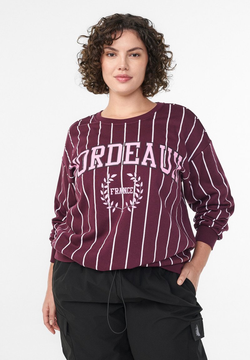 Bordeaux dolgi rokav s škatlasto kapuco v temno rdeči barvi z belimi navpičnimi črtami, na prsih ima napis "BORDEAUX" in "FRANCija", ter grafiko lovorjevih vejic.