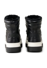 Black leather ankle boots with a textured finish, featuring a plush black lining, white midsole, and branding detail on the back.