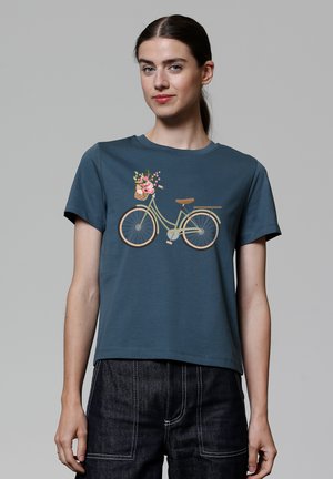 T-shirt en coton teal à manches courtes, avec un graphique de bicyclette orné de fleurs dans un panier.