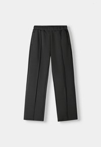 Pantalon large noir en tissu doux, avec une ceinture élastique et deux poches latérales, au design épuré et minimaliste.