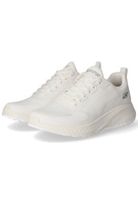 Białe sportowe buty z siateczkową cholewką, teksturowanym żebrowaniem, sznurowanym przodem i wyściełanym kołnierzem. Posiadają teksturowaną podeszwę dla lepszej przyczepności.