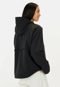 Zwarte hoodiejas met een relaxed fit, matte textuur en een rechte zoom met een verstelbare trekkoord in de capuchon en bij de mouwen.