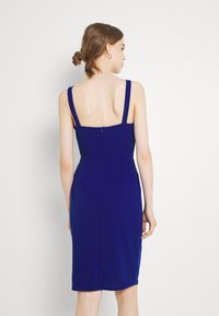 Vestido justo azul-marinho com alças largas, costas quadradas e fecho com zíper. Feito de um material liso e elástico, com um design até aos joelhos.