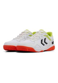 Scarpe sportive da uomo con parte superiore in mesh bianco, dettagli neri, evidenze verdi vivaci e una suola in gomma rossa con un motivo a zigzag.