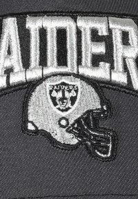 Schwarze Baseballmütze mit weiß gesticktem "RAIDERS"-Text und einem silbernen Footballhelm-Logo mit einem Schilddesign.