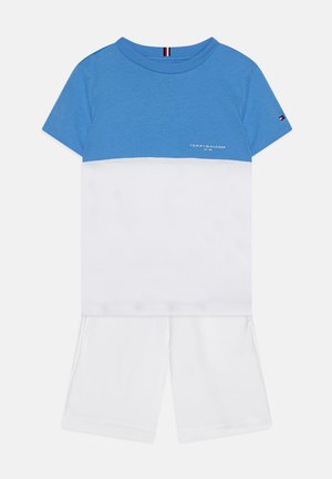Blå och vit kortärmad T-shirt med rund hals; kombinerad med vita shorts. Inkluderar logotypdetalj på bröstet och en liten detalj på ärmen.