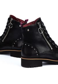 Stivaletti neri in pelle con superficie testurizzata, dotati di zip laterale, lace-up anteriore, dettagli borchiati e suola spessa nera.