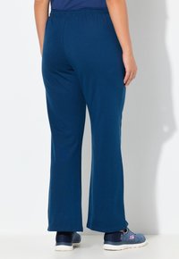 Granatowe, lekkie spodnie o rozkloszowanym kroju z elastycznym paskiem. Miękka faktura i swobodny design odpowiedni do różnych aktywności.