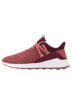 Chaussure de sport bordeaux et rose avec texture tricotée, semelle blanche et fermeture à lacets, vue de profil sur fond blanc.