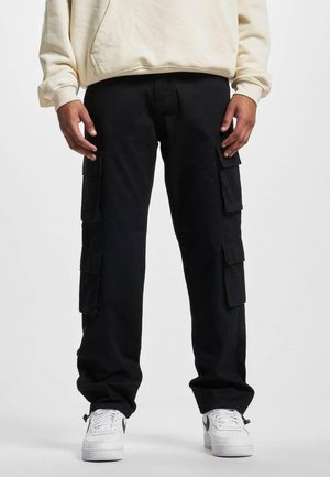 Black cargo pants made of durable fabric, featuring multiple side pockets and a straight-leg design, paired with white sneakers.